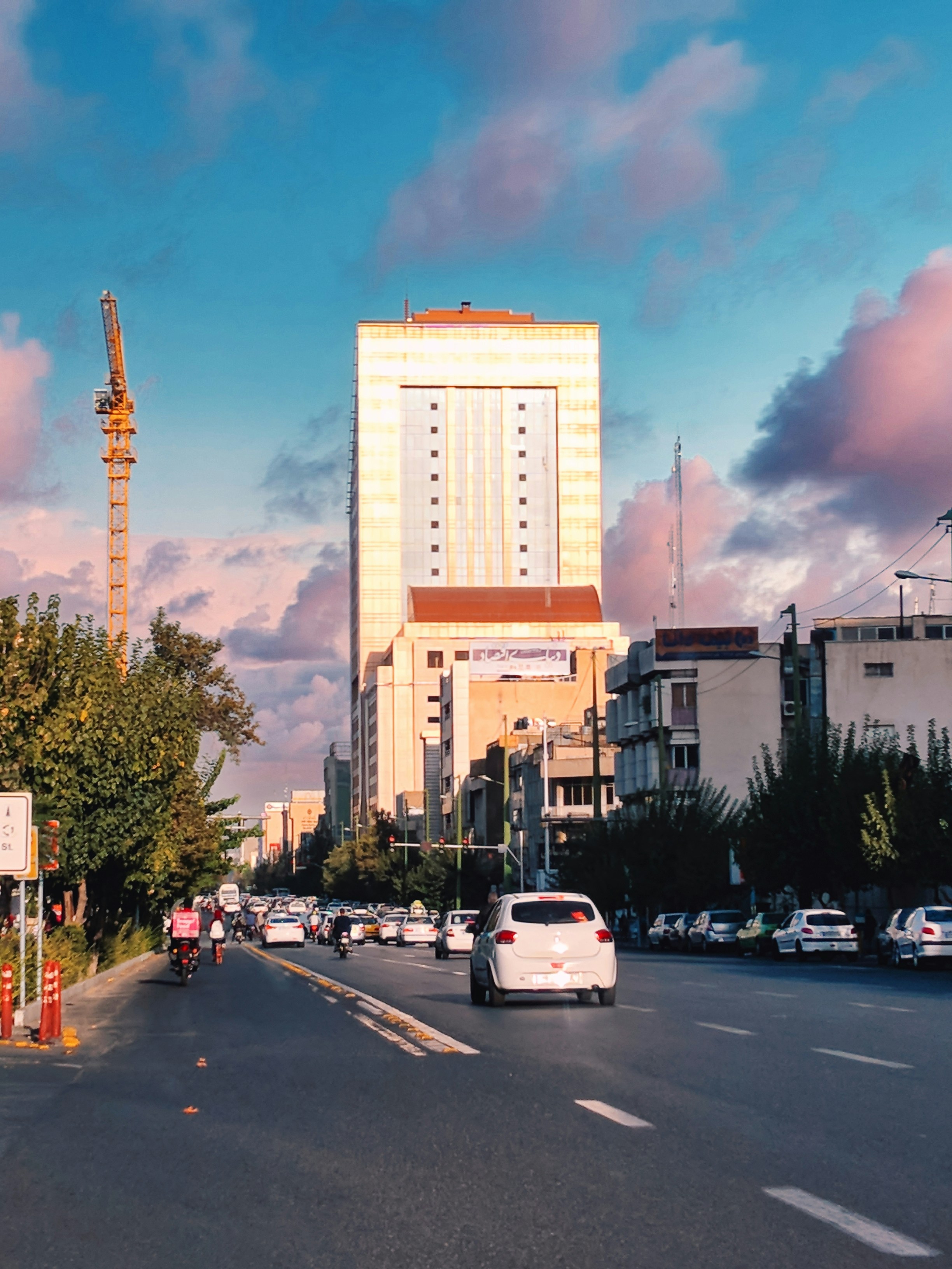 a city street filled with traffic next to tall buildings