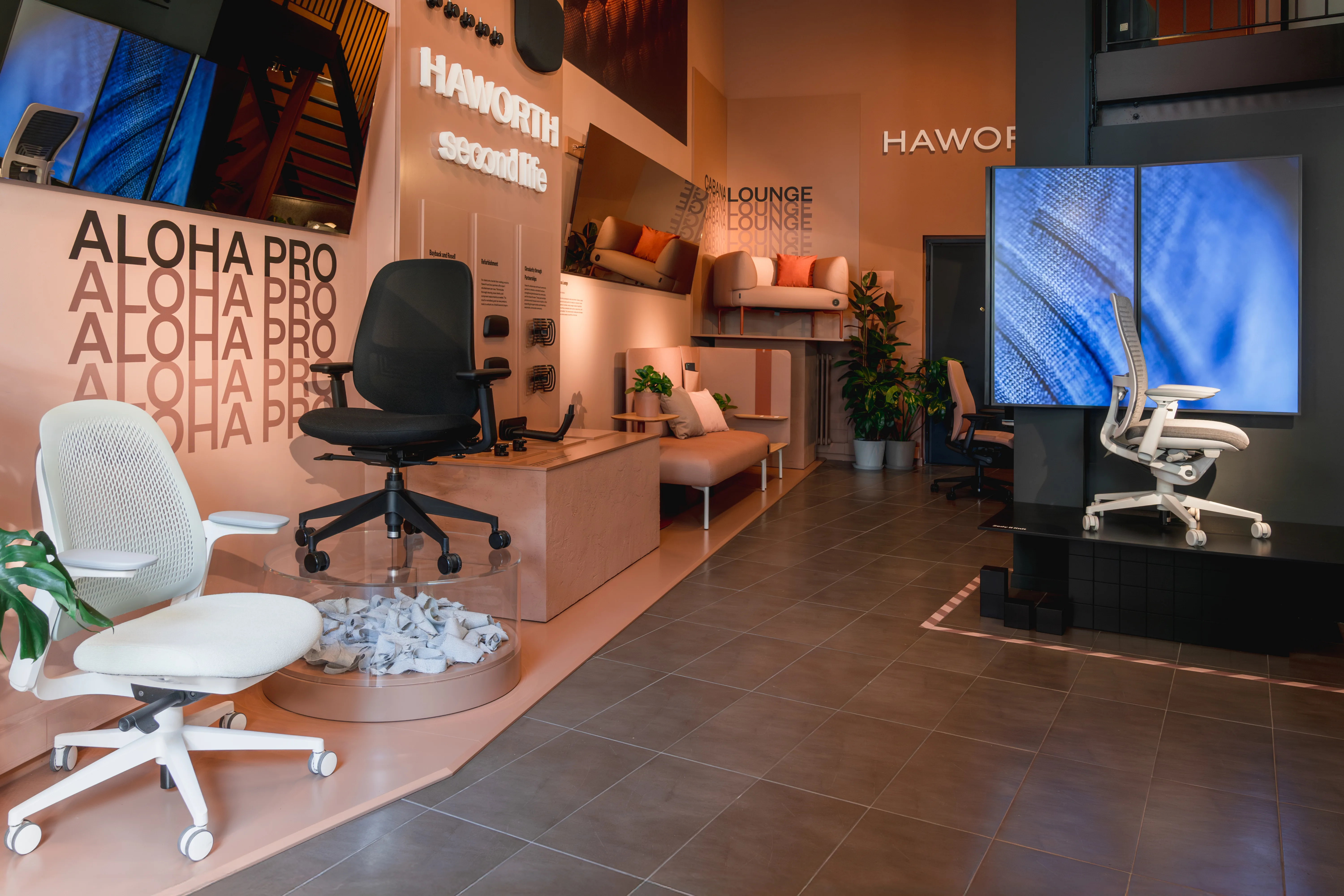 View through the Haworth showroom with Aloha Pro presentation, lounge niche and large chair video screen.