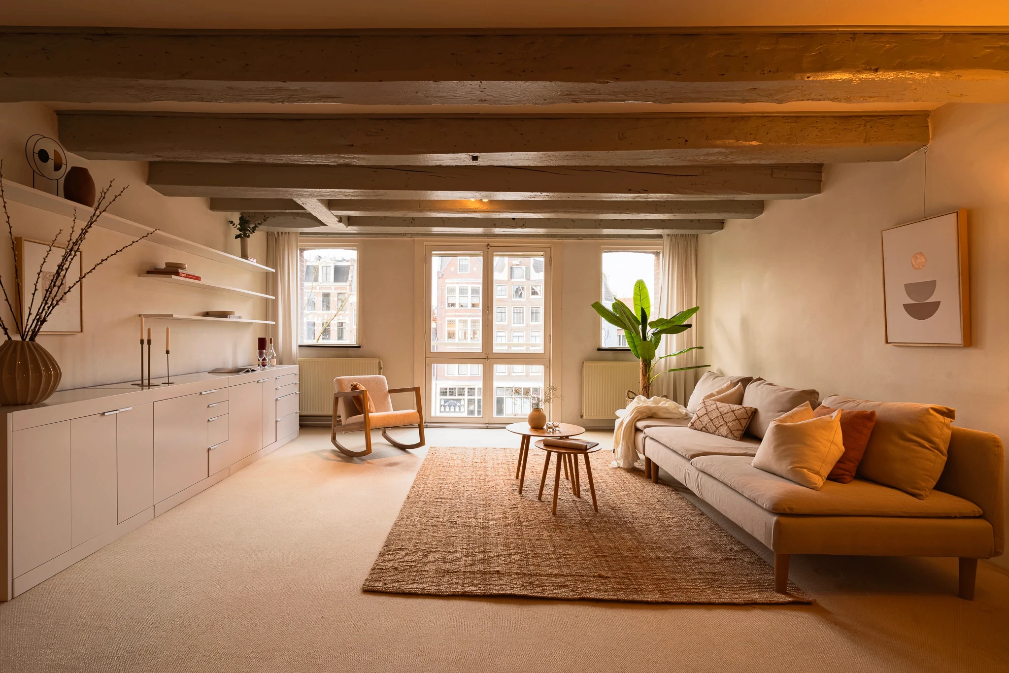 Open-plan living space with exposed beams and a long sofa