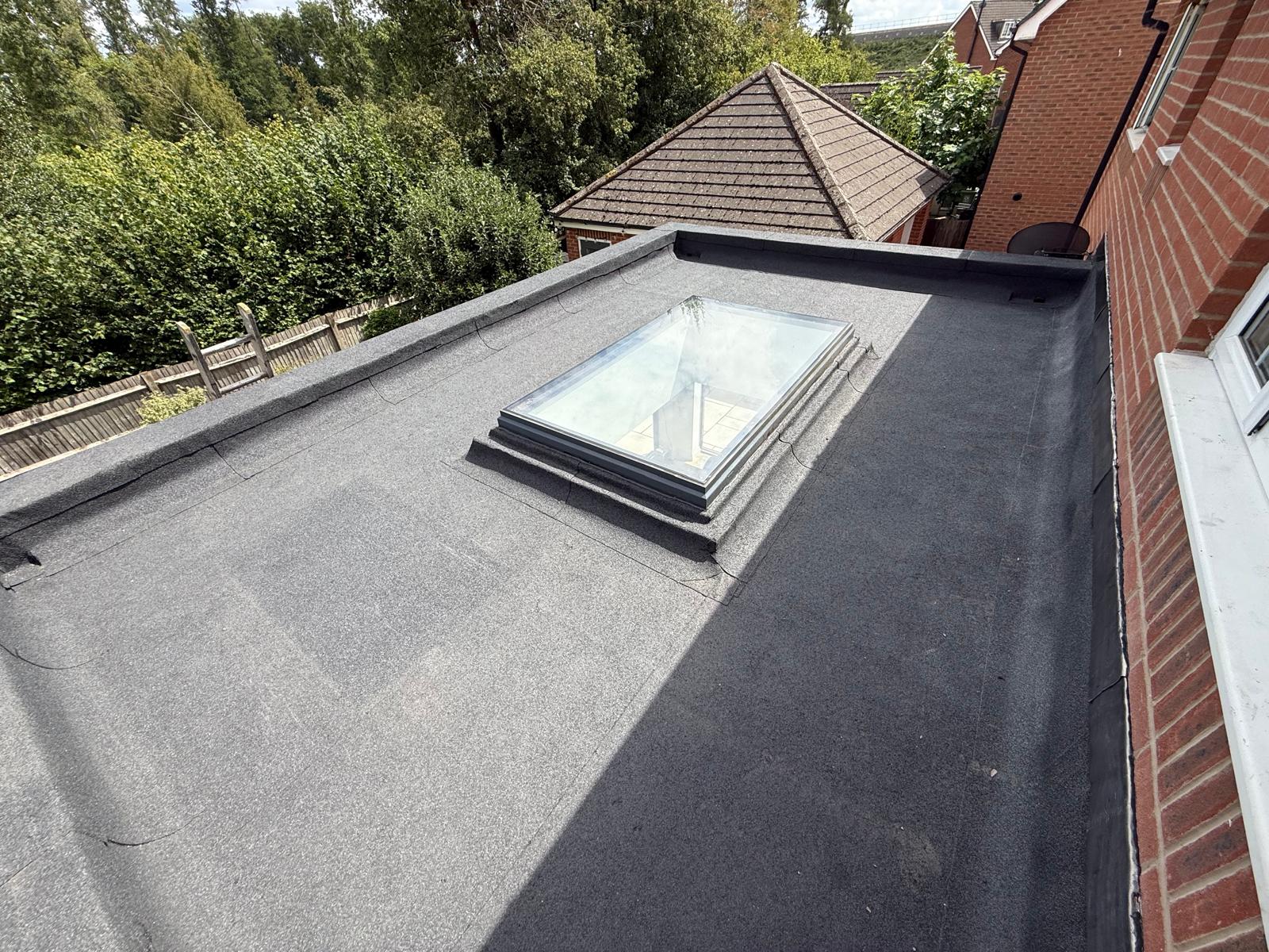 Close-up of a brick wall with lead flashing and guttering on the edge of a pitched roof in the UK.