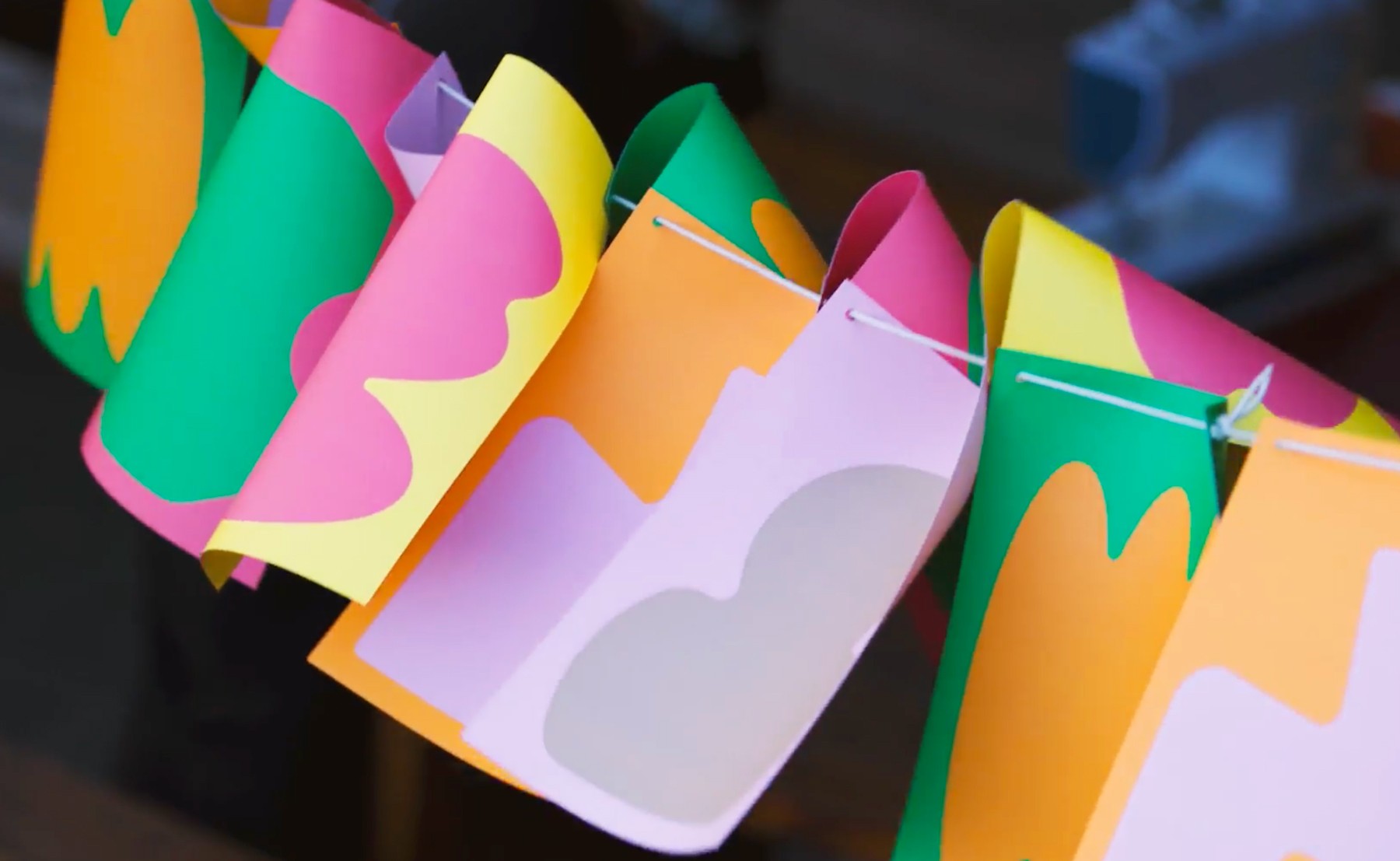 A row of flags with colourful shapes designed as decoration at a festival.