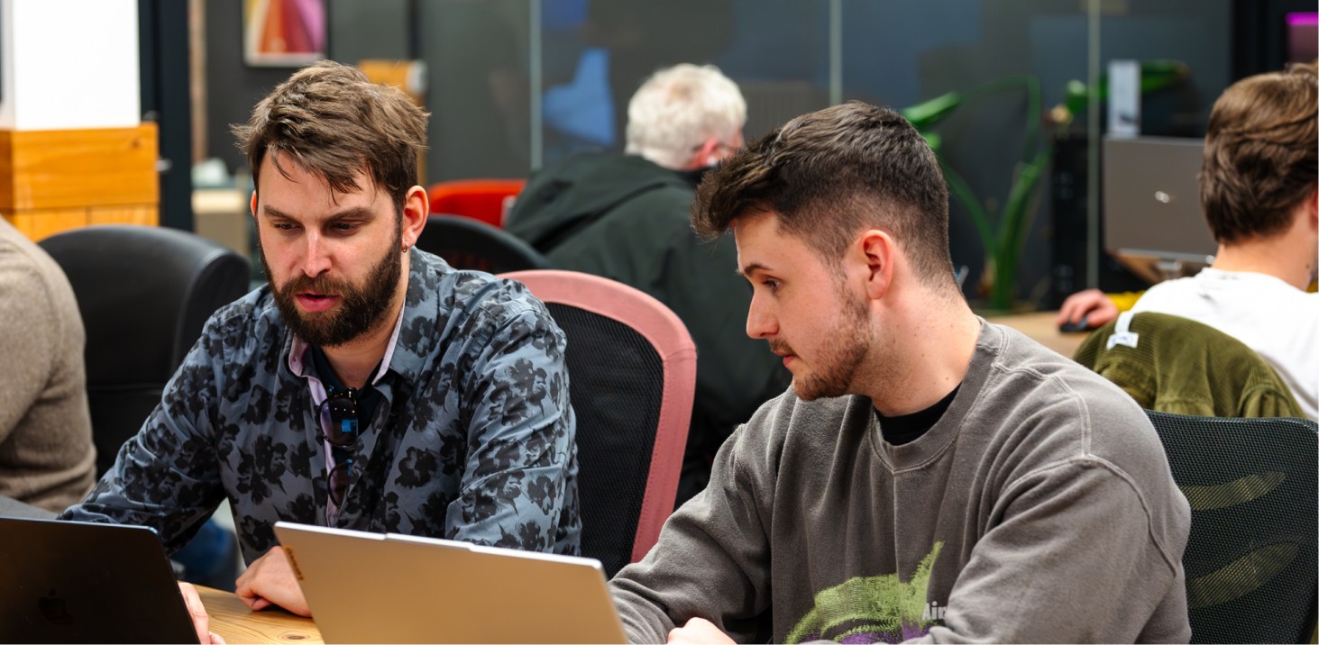 People working on laptops in a meeting room.