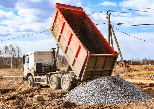 Dump truck unloading gravel for a construction project at an active job site in Kansas City