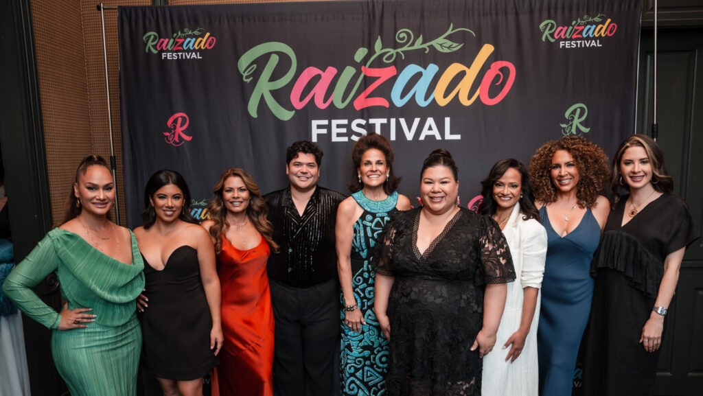 Group posing in front of a Raizado Festival backdrop