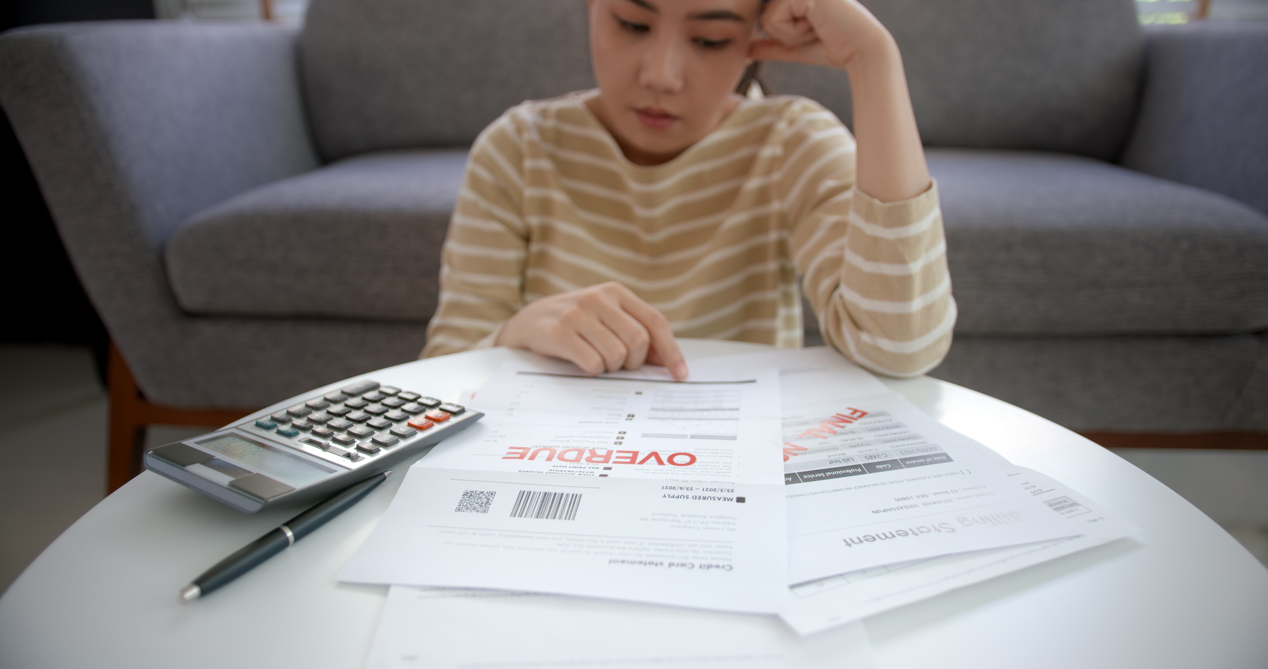 Person sitting at a desk reviewing tax documents and using a calculator after a divorce, representing post-divorce tax filing guidance for Massachusetts residents