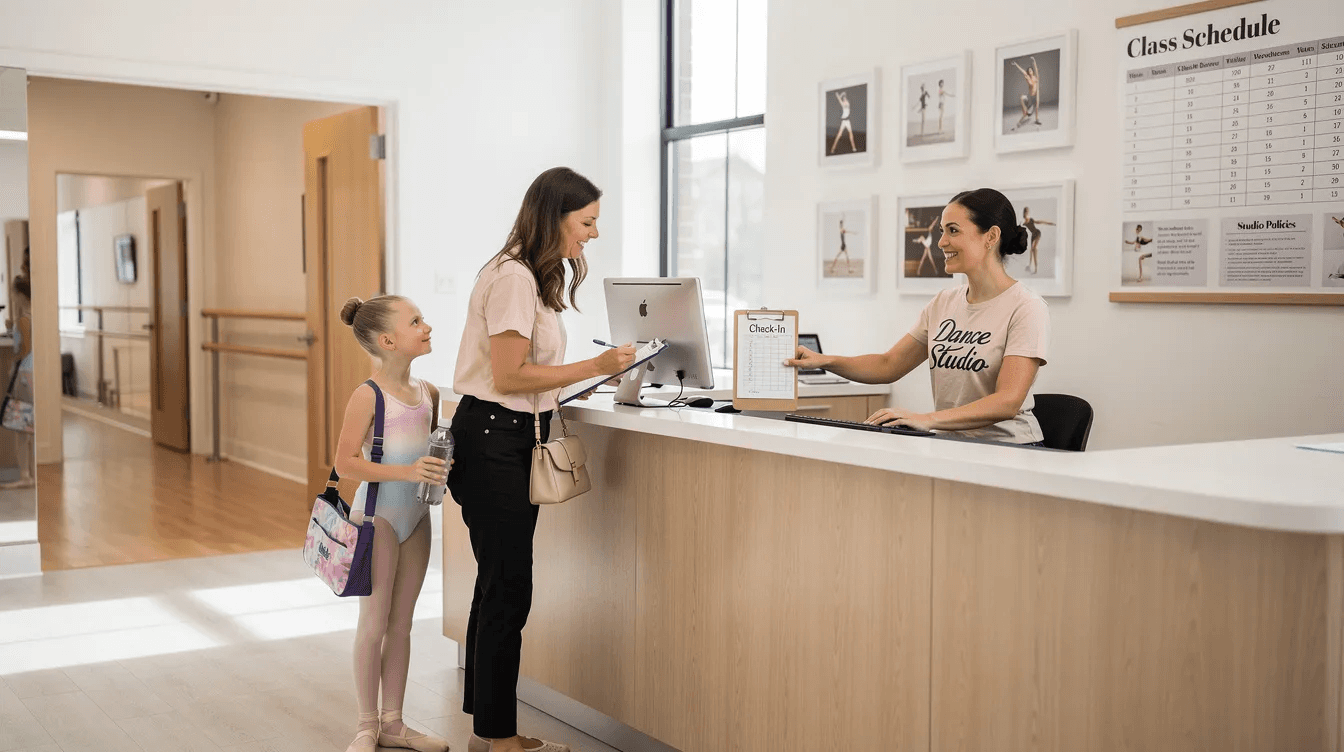 A parent and a young dancer are checking in at a dance studio reception desk, surrounded by vibrant posters of dance classes and schedules. This scene highlights the welcoming atmosphere of the dance studio, where dance studio management software helps streamline check-ins and enhance student engagement.
