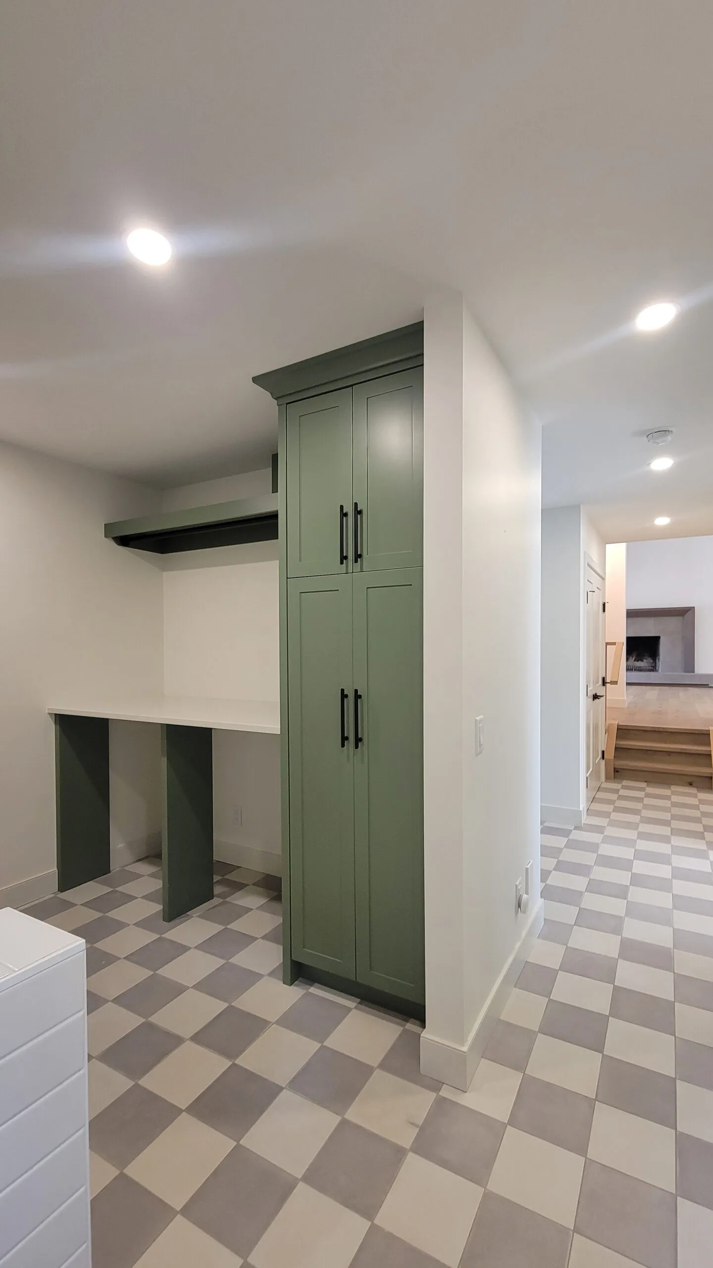 Image of laundry room with green millwork, but no machines.