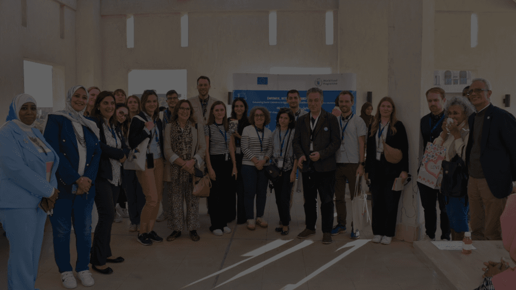 woman in blue tank top standing beside white wall