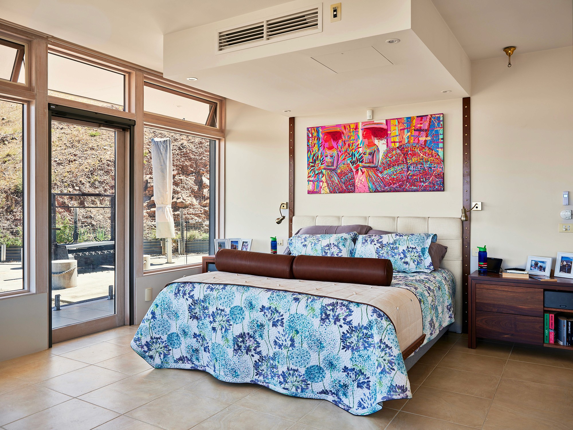 Bright bedroom with colorful bedspread and wall art