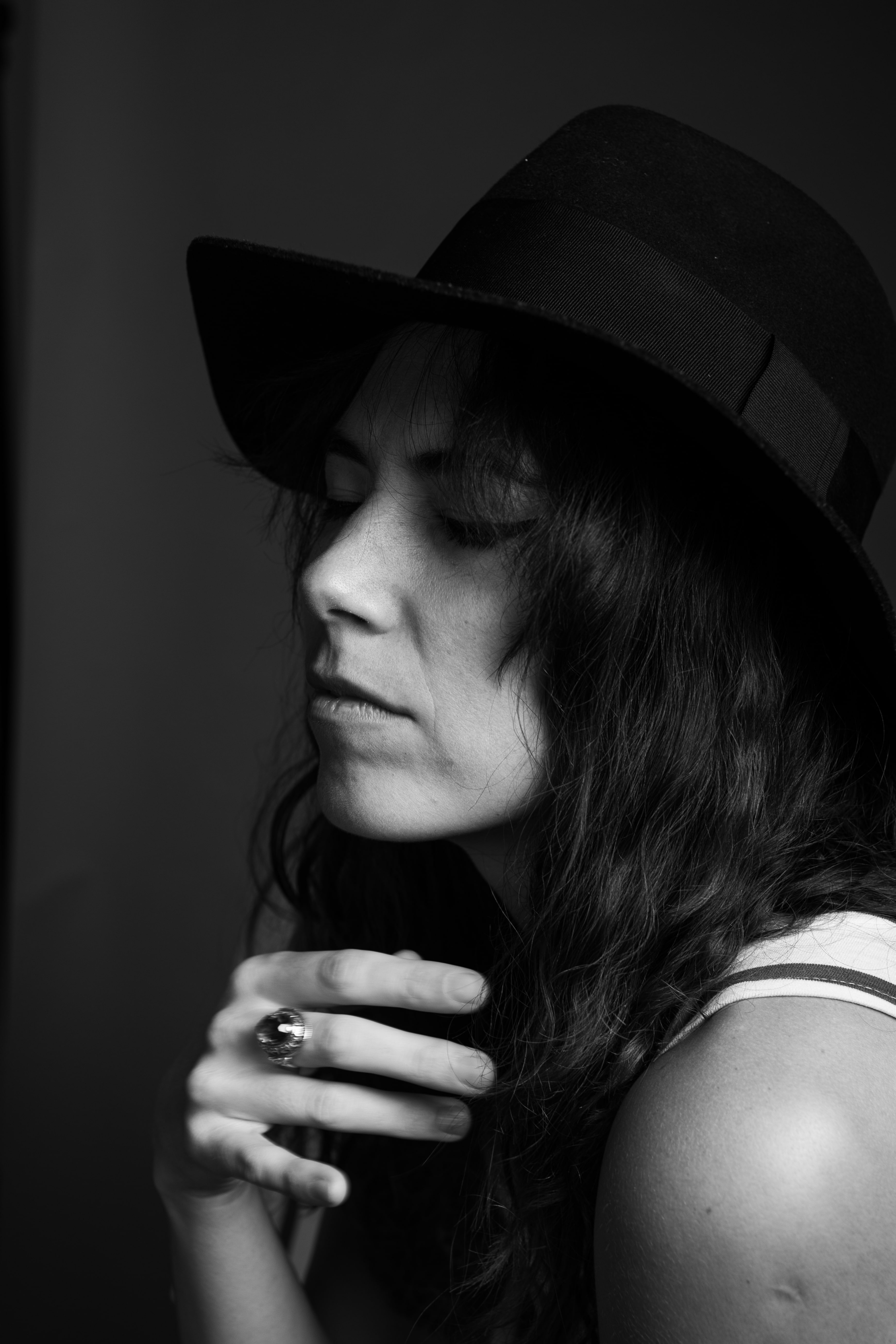 Młoda kobieta w kapeluszu na ciemnym tle