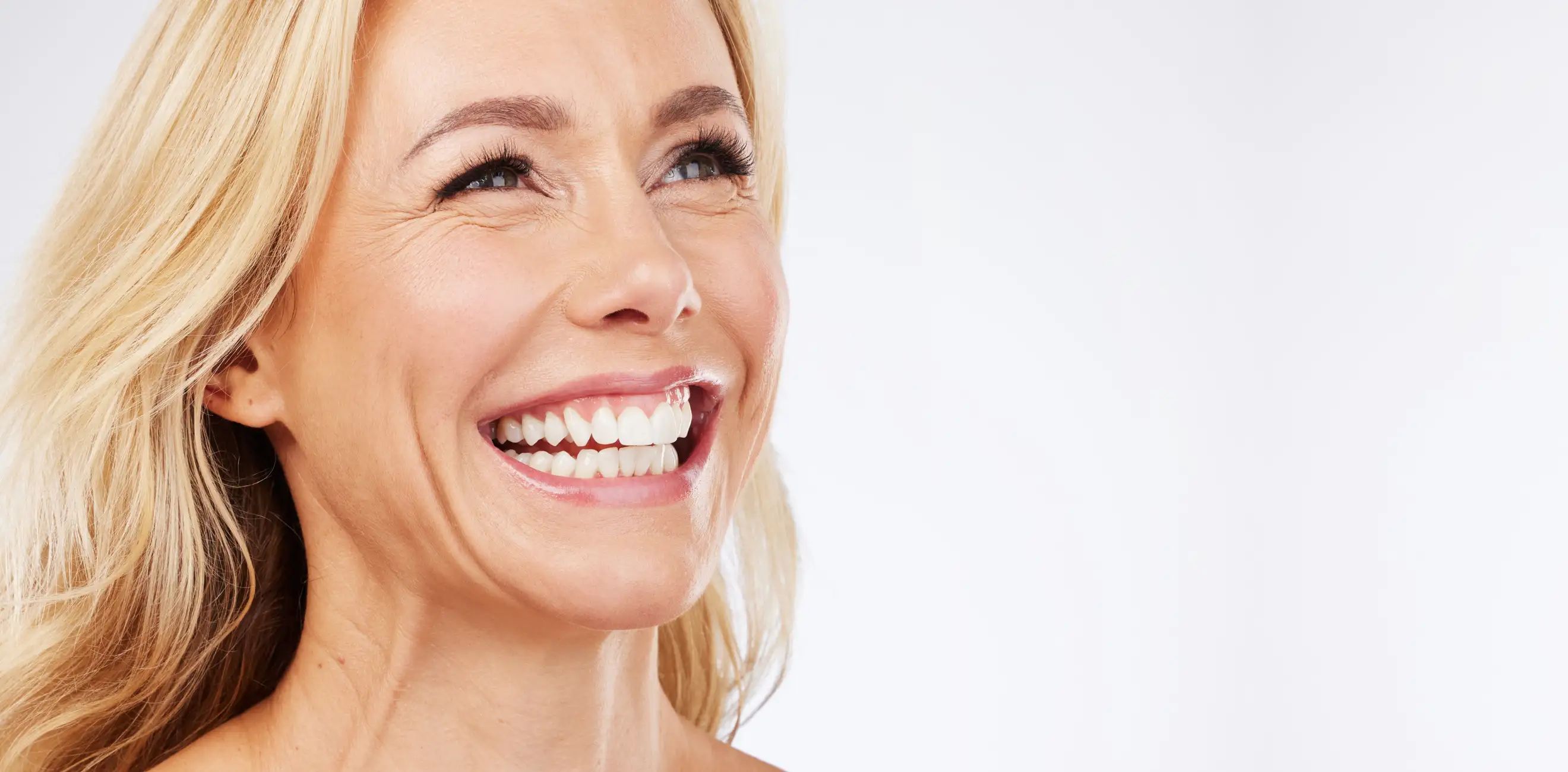 Kobieta z uśmiechem prezentująca efekty implantu.