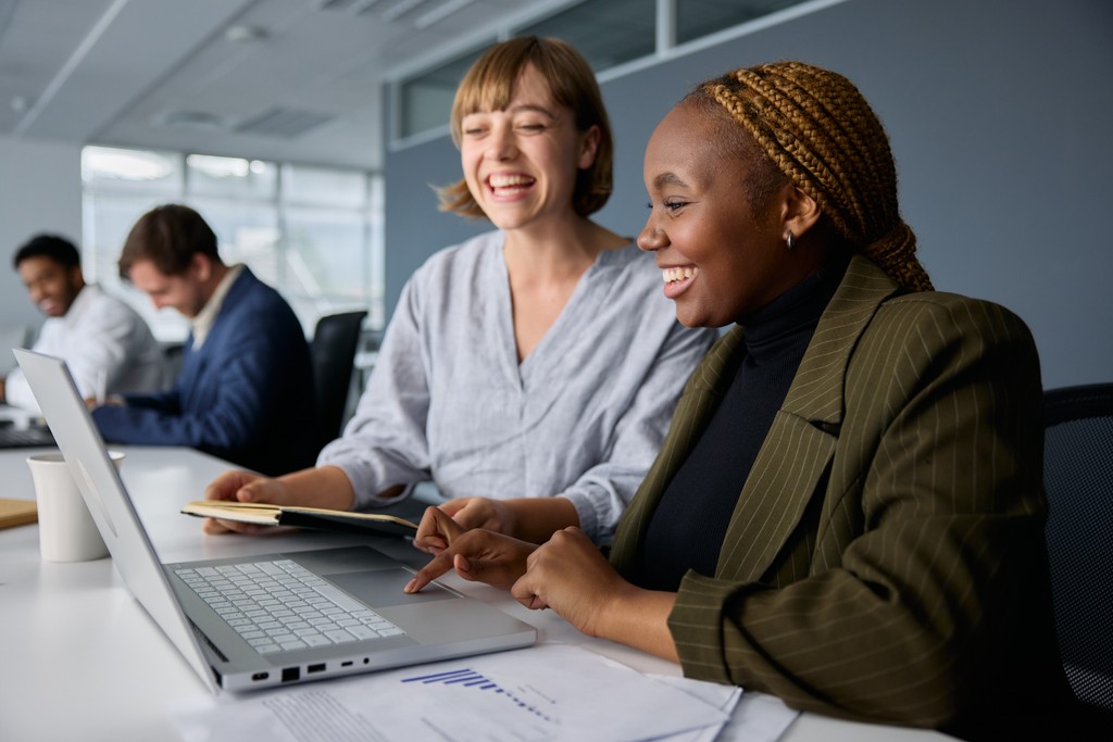 Woman smiling as she is coached on how to write a CV.