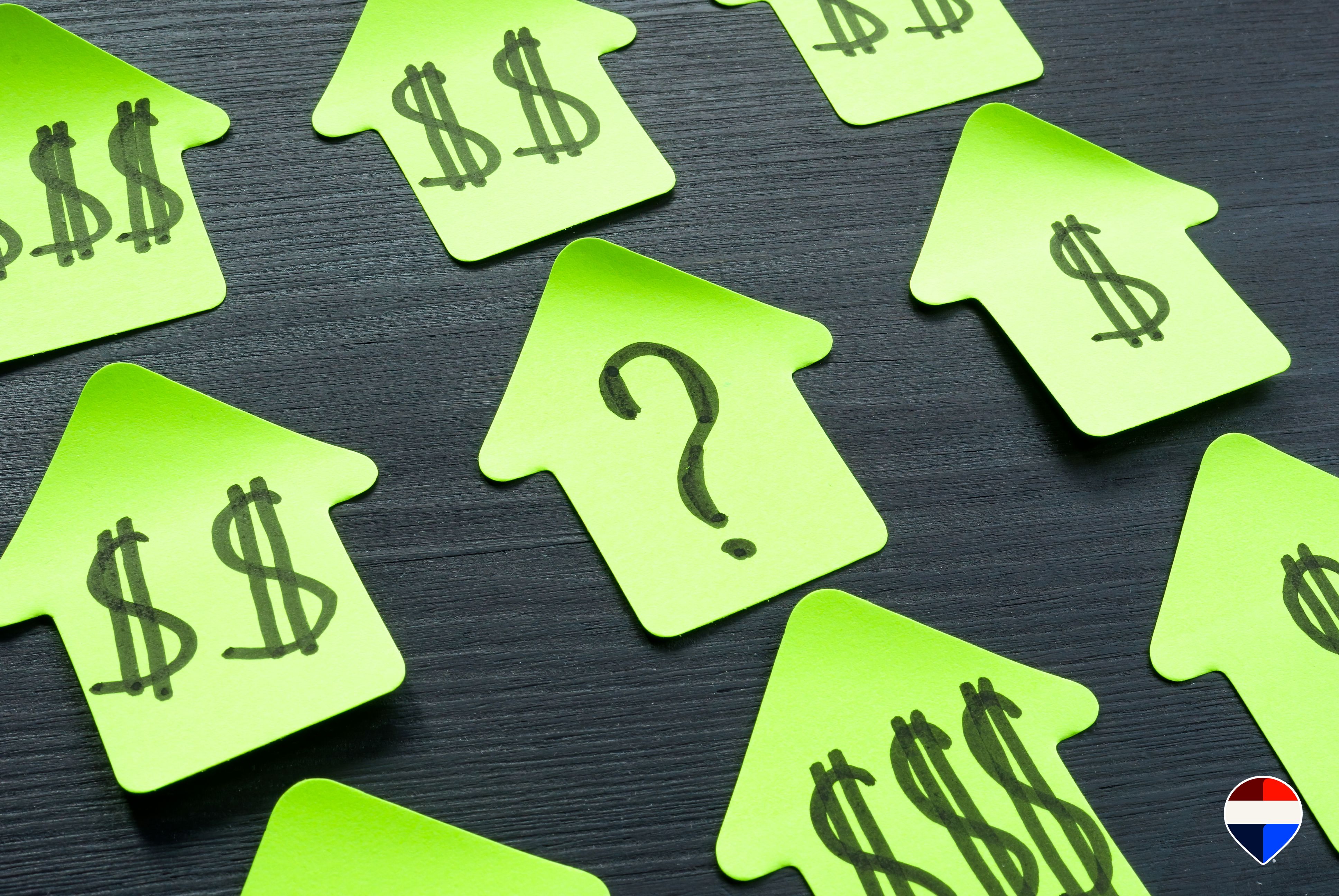Post-it a forma di casa con simboli di prezzo e un punto interrogativo: quanto vale davvero la mia casa