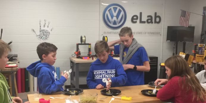 Students around a table at Normal Park Museum Magnet Upper School.