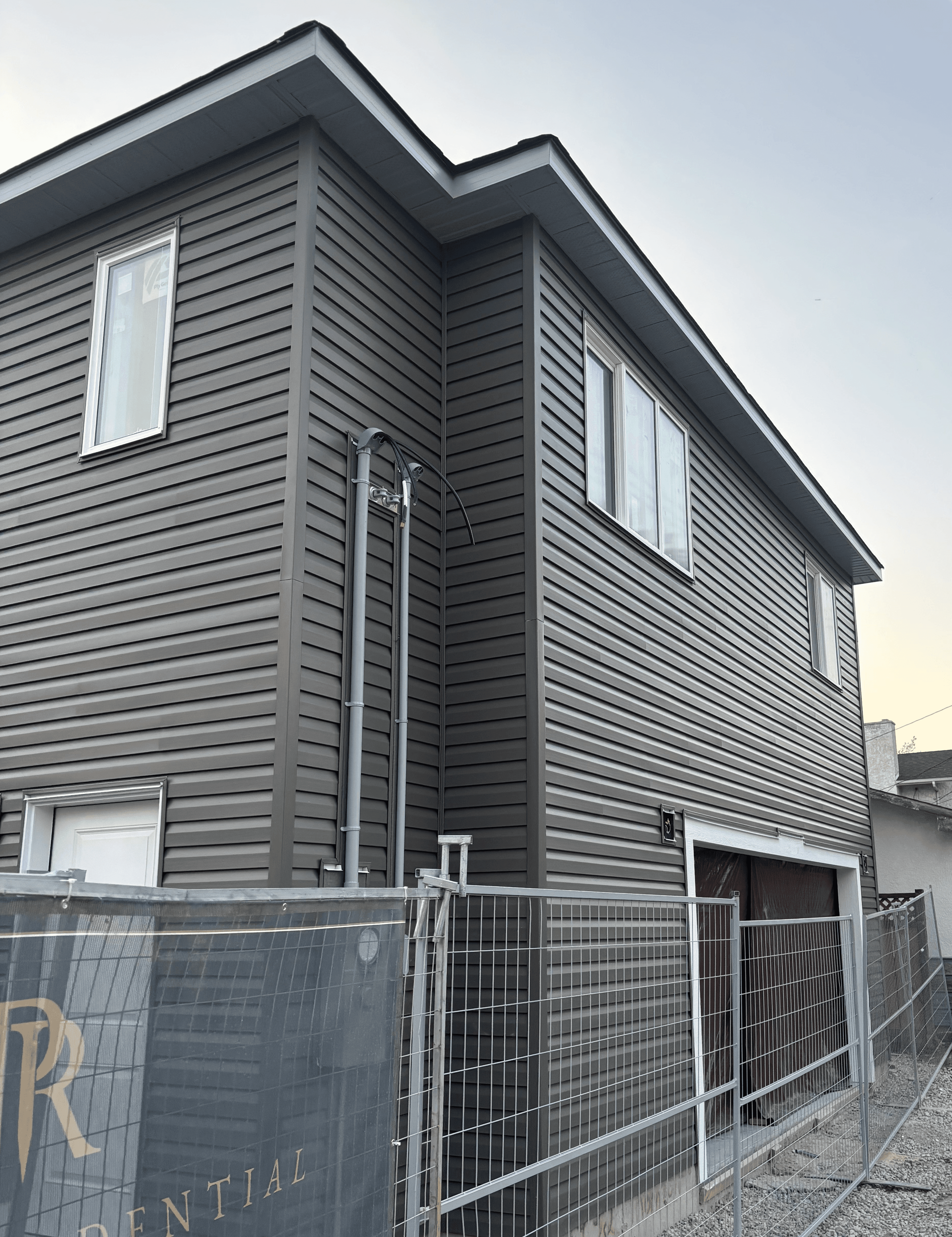 Front elevation of garage suite—vinyl siding, vented soffit, and framed garage opening