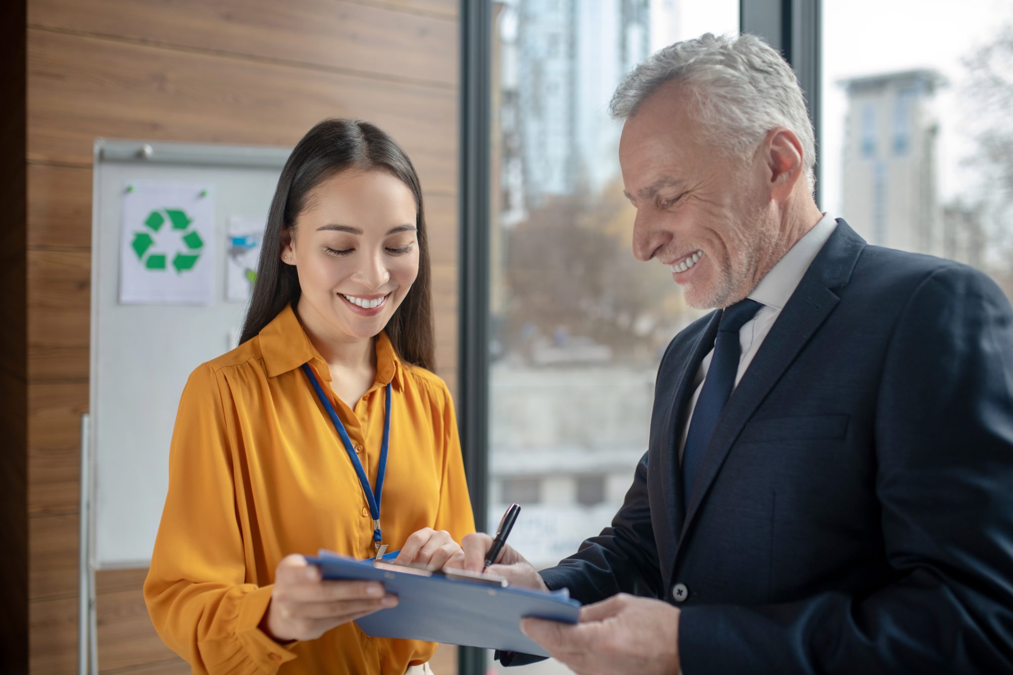 Close-up of lush, dark green leaves, some glossy and wet, against a muted background.