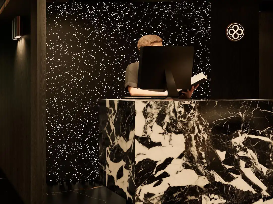 Comptoir d’accueil en marbre noir et blanc devant un mur piqué d’étoiles (visuel d’architecte)