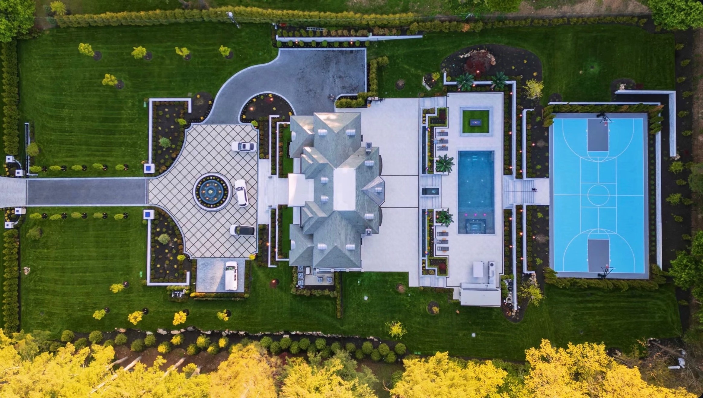 Modern farmhouse estate lit with landscape lighting at night by Bonilla Irrigation & Contracting, Long Island NY