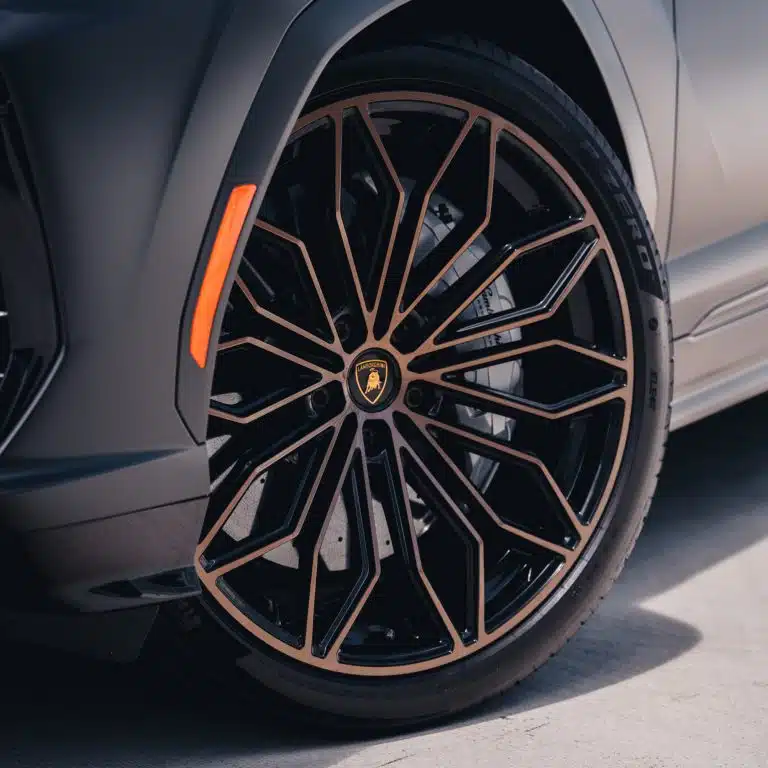Close-up of the black and bronze multi-spoke wheel and tire on the Lamborghini Urus SE.