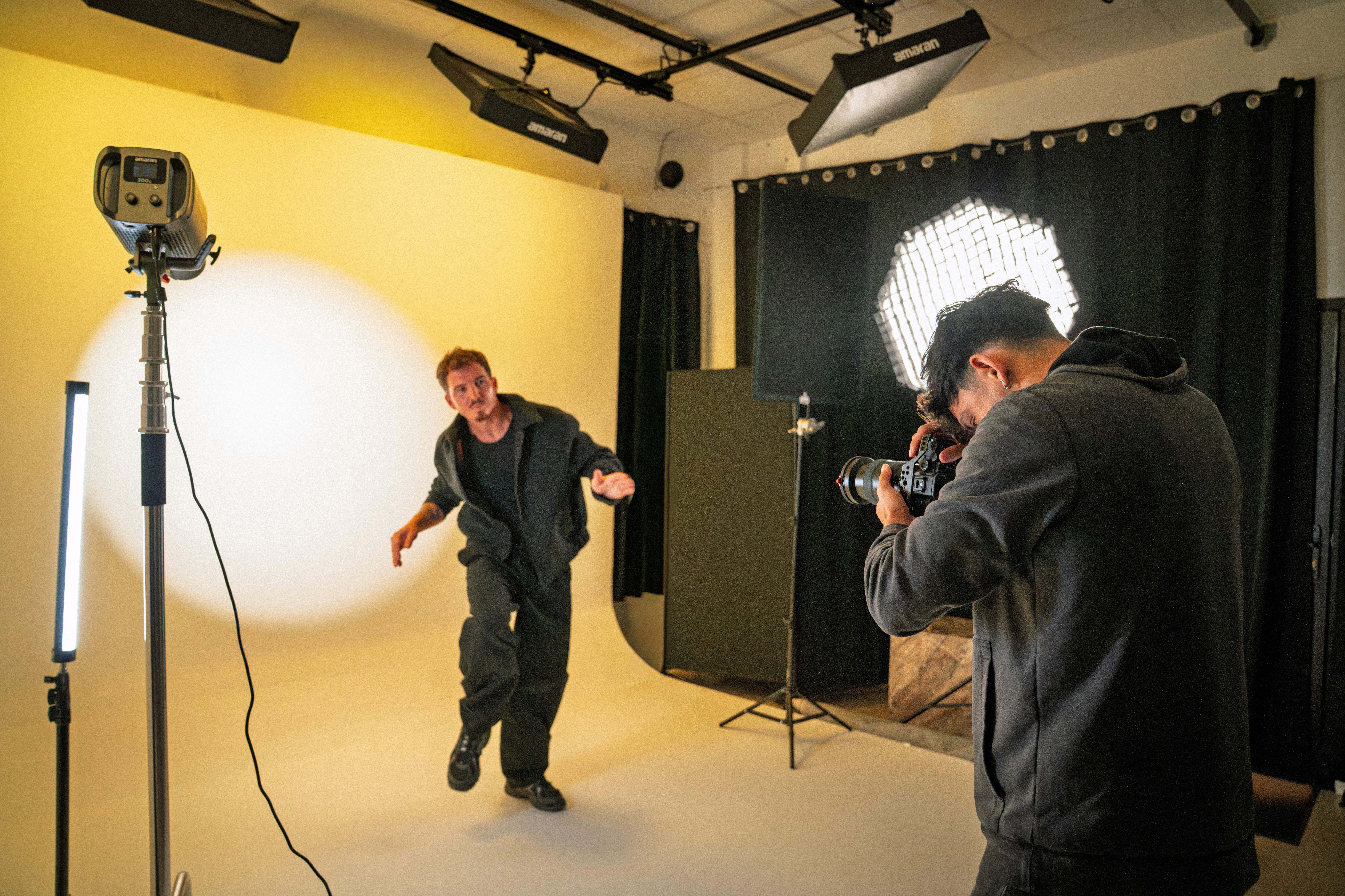 Black and white image of people working at a table with laptops, showing hands gesturing during discussion of digital content displayed on screens, with fabrica® logo in the corner.