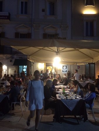 tavoli all'aperto di pnineria notturna a Roma con ombrelloni affollato 