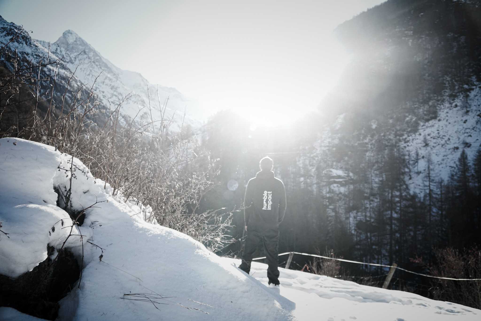 Modern red brick apartment or office building viewed from below against a blue sky, showcasing its geometric architecture with evenly spaced windows and balconies.