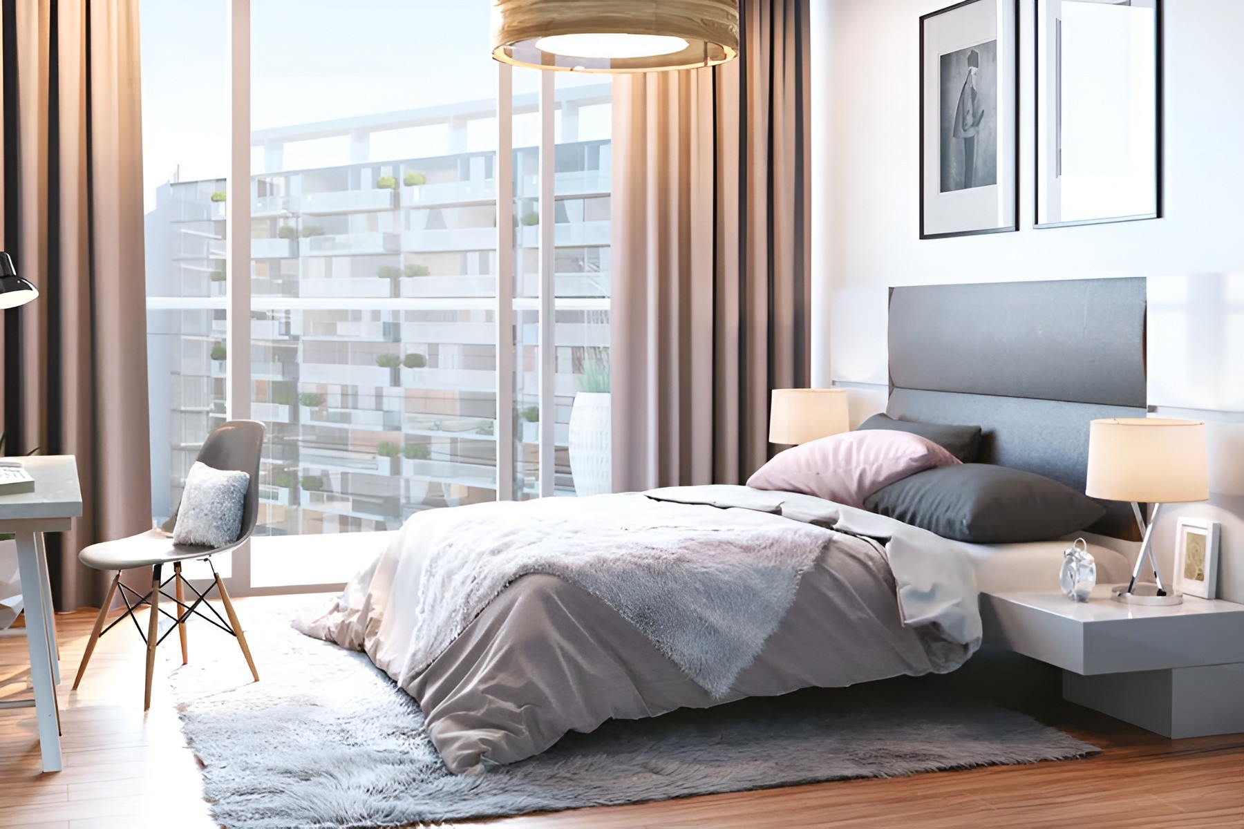 Interior of a contemporary bedroom at Azizi Mirage, showcasing a bed, a desk, and a bright window.