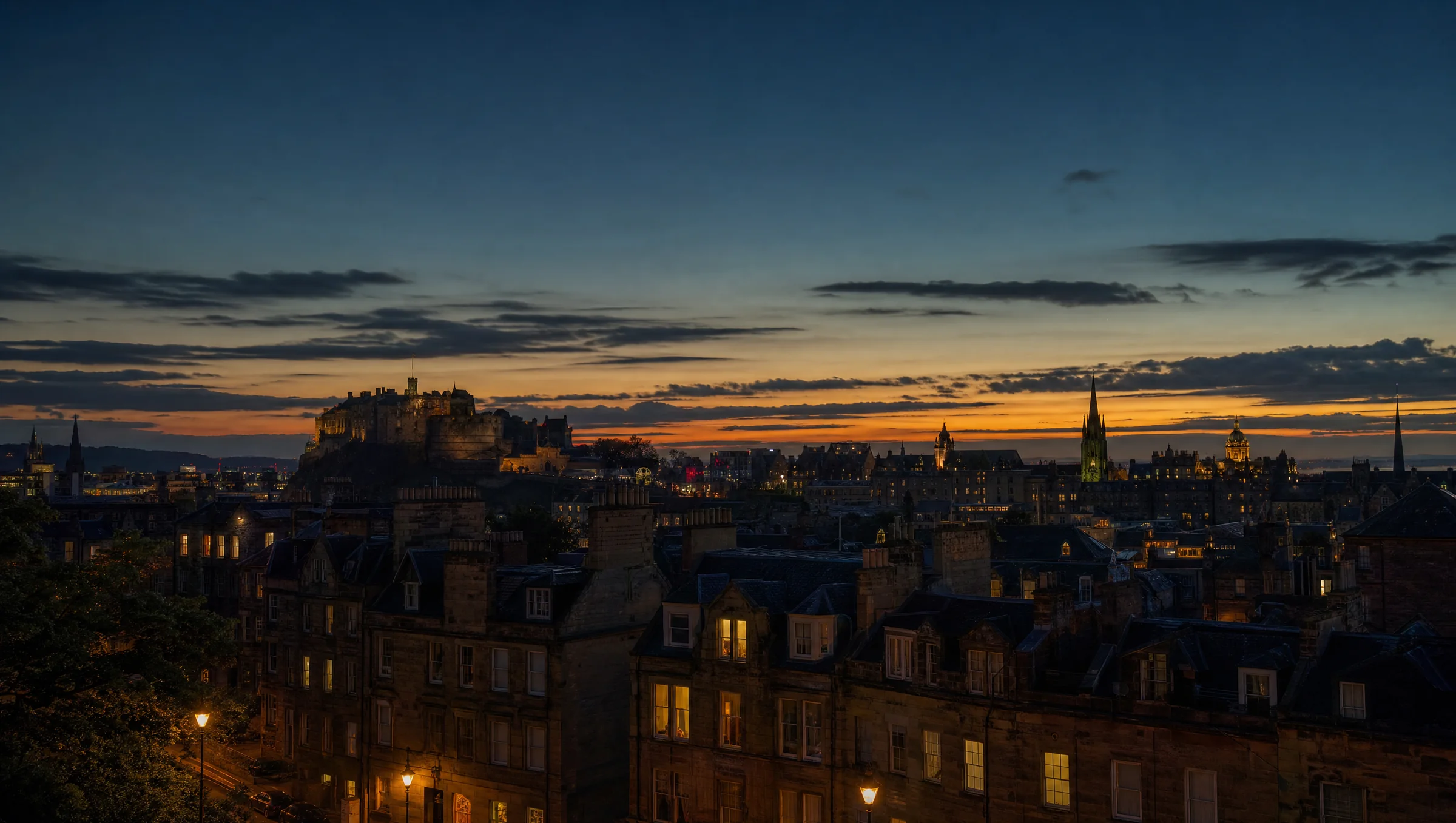 Edinburgh rooftops and the castle at dusk from Calton Hill