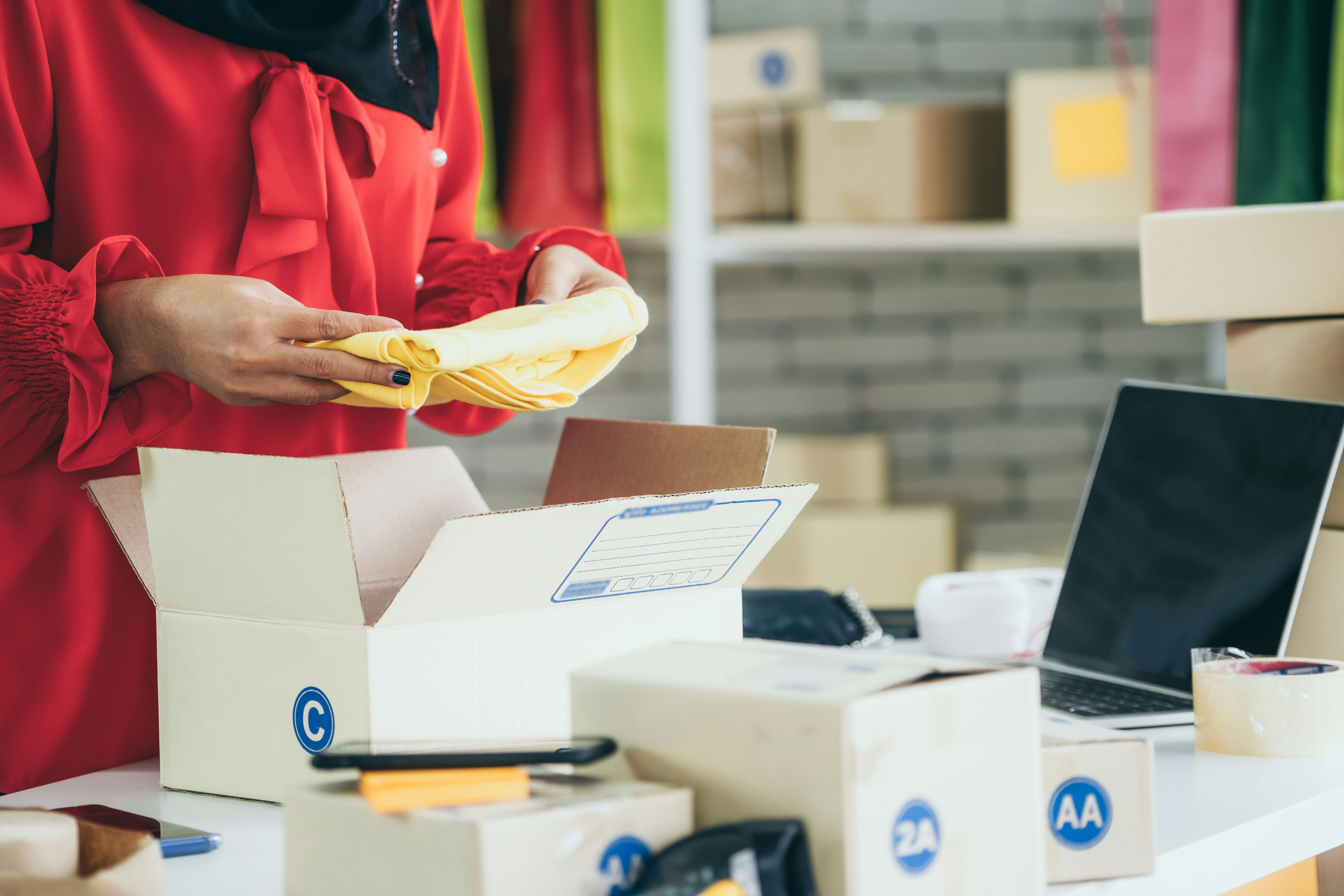 warehouse worker putting items into kitting boxes