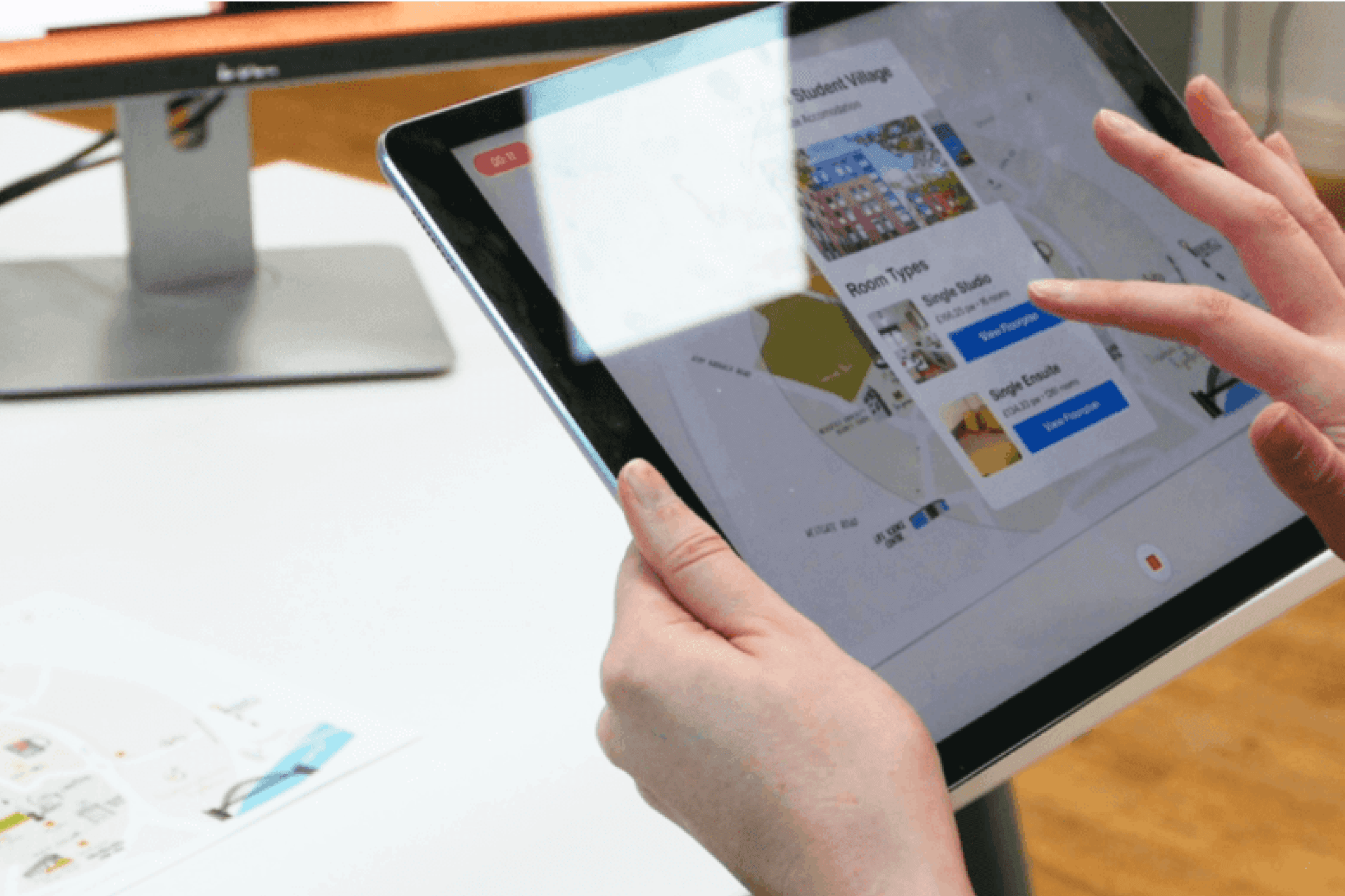 A person holding a tablet selecting a room while using an AR application to scan a map