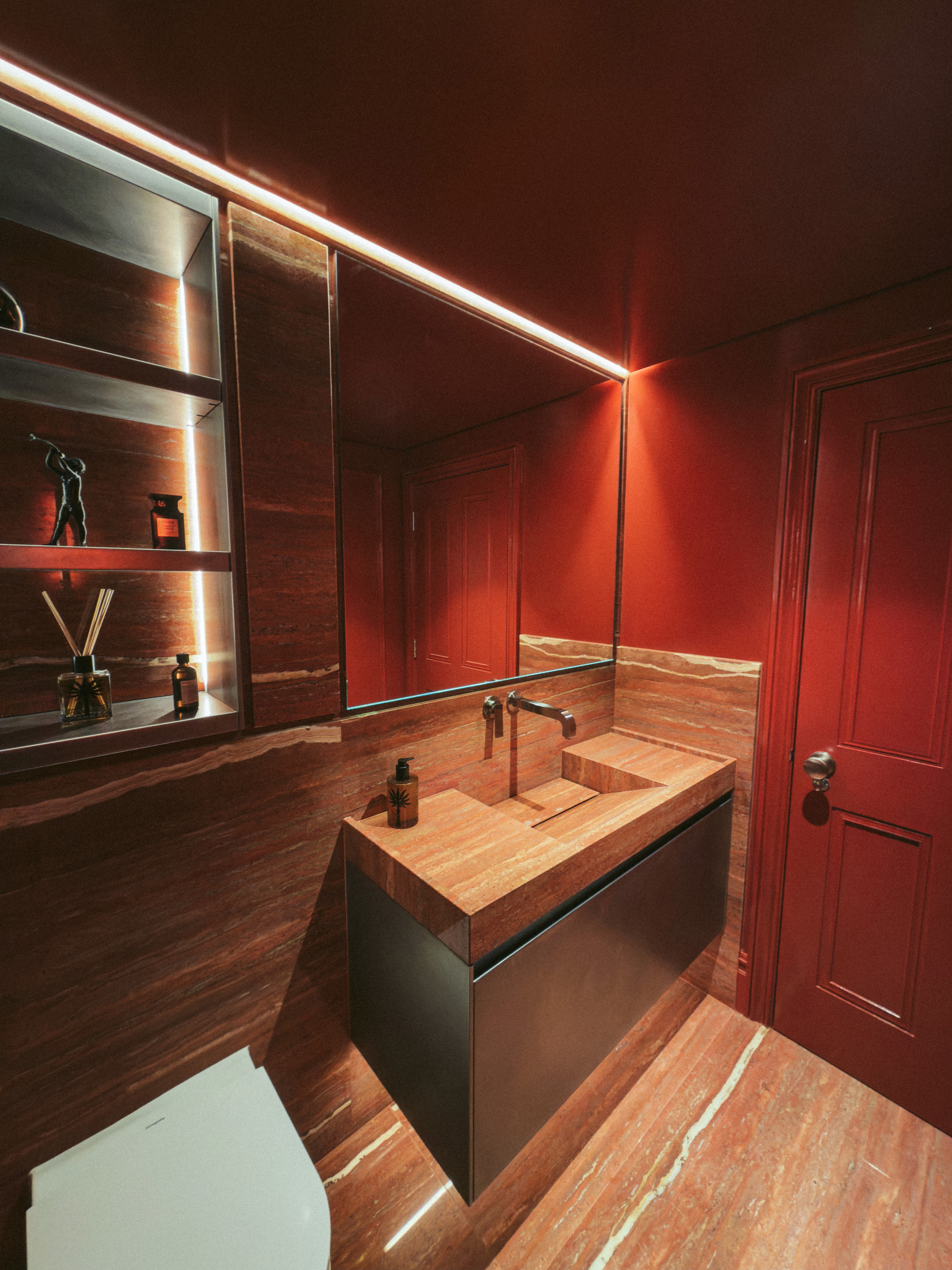 Deep red bathroom interior with red travertine flooring and stone sink
