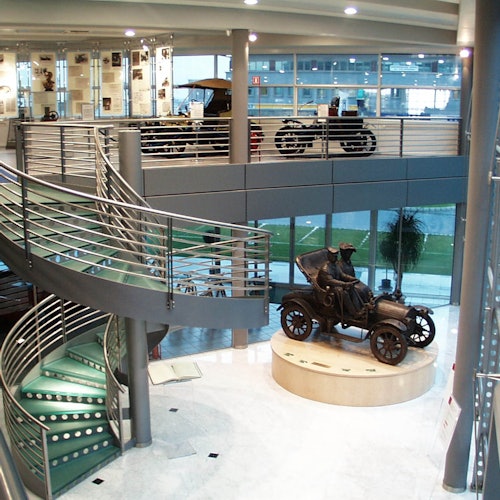 یک موزه داخلی با پلکان مارپیچ، دیوارهای شیشه‌ای، نمایشگاه‌های ماشین‌های قدیمی و نمایشگاه‌های وسایل نقلیه کلاسیک در دو طبقه.