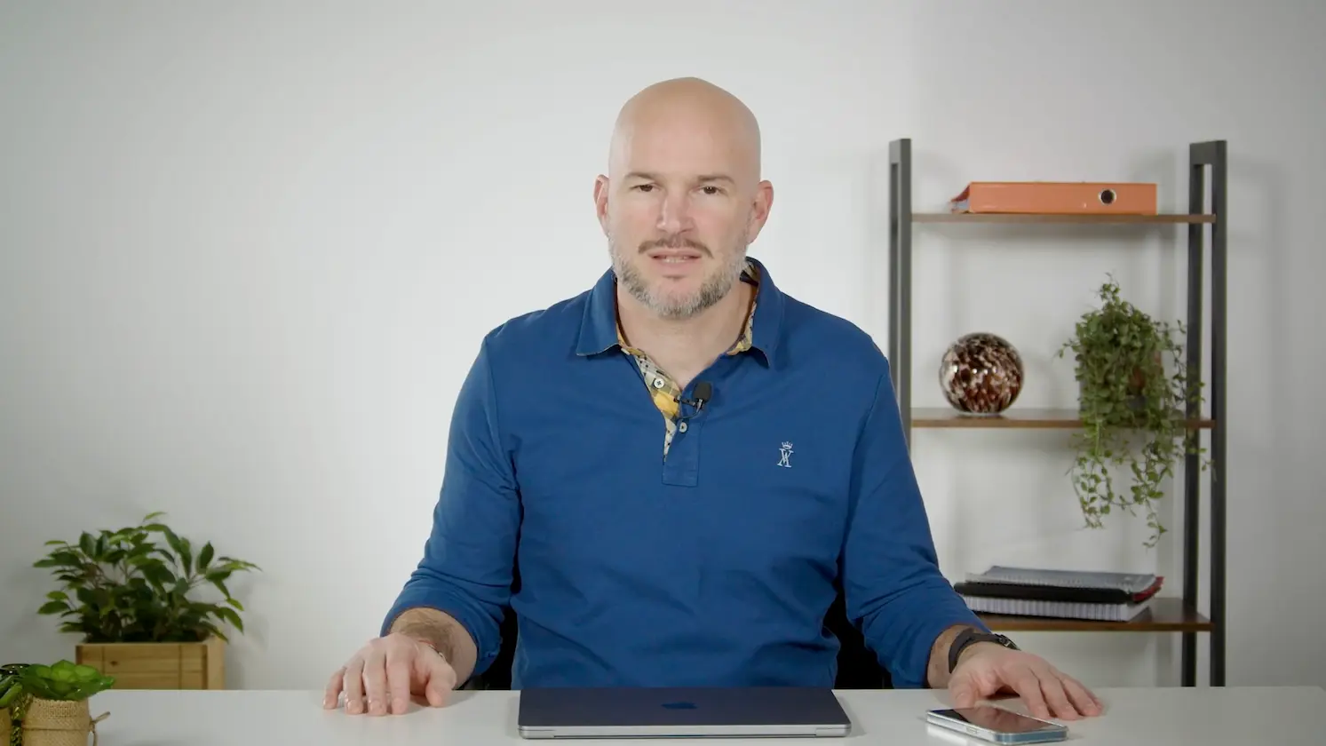 Homme assis à un bureau face caméra dans un environnement professionnel, présentant des conseils de détente au travail