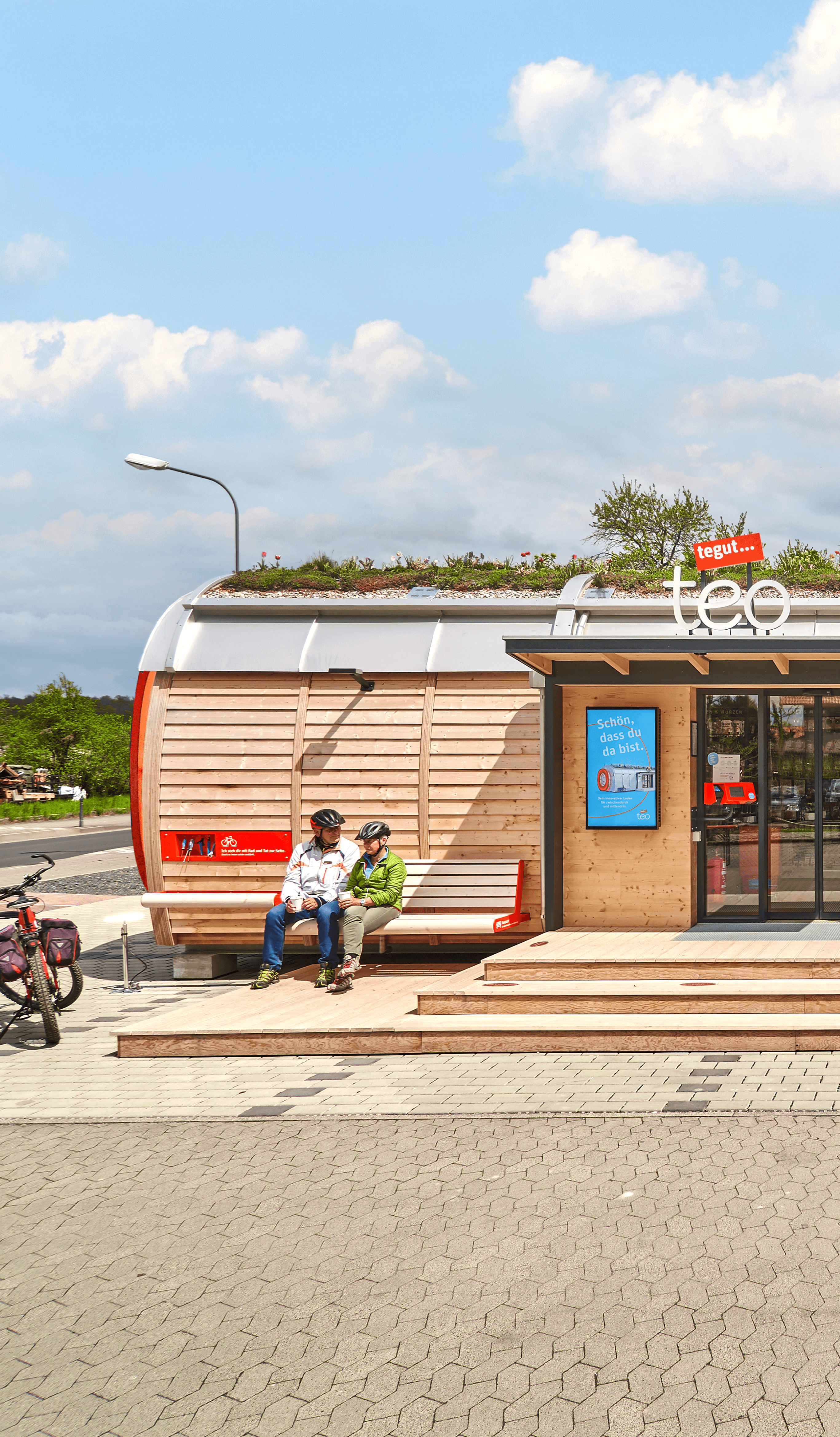 Frontansicht des tegut… teo in Rasdorf mit Kund:innen – nachhaltiges Micro-Store Konzept gestaltet von Design for Human Nature in Hamburg.