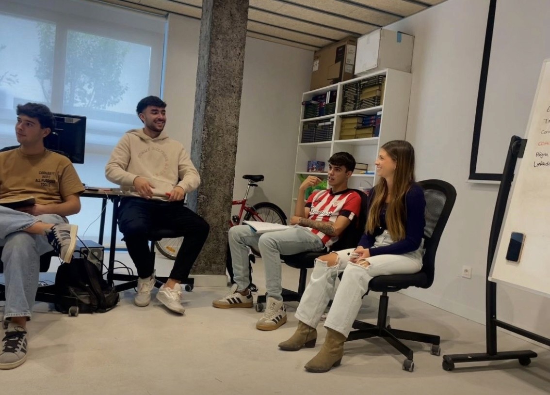 Close-up of a dark green leaf showing its textured surface and central vein against a muted background.