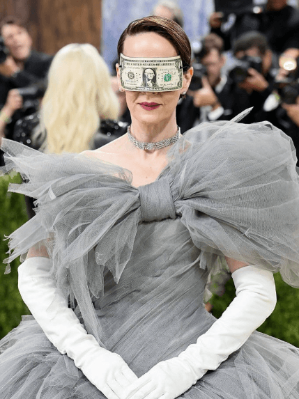 A person in a dress with a dollar bill over her eyes

AI-generated content may be incorrect.
