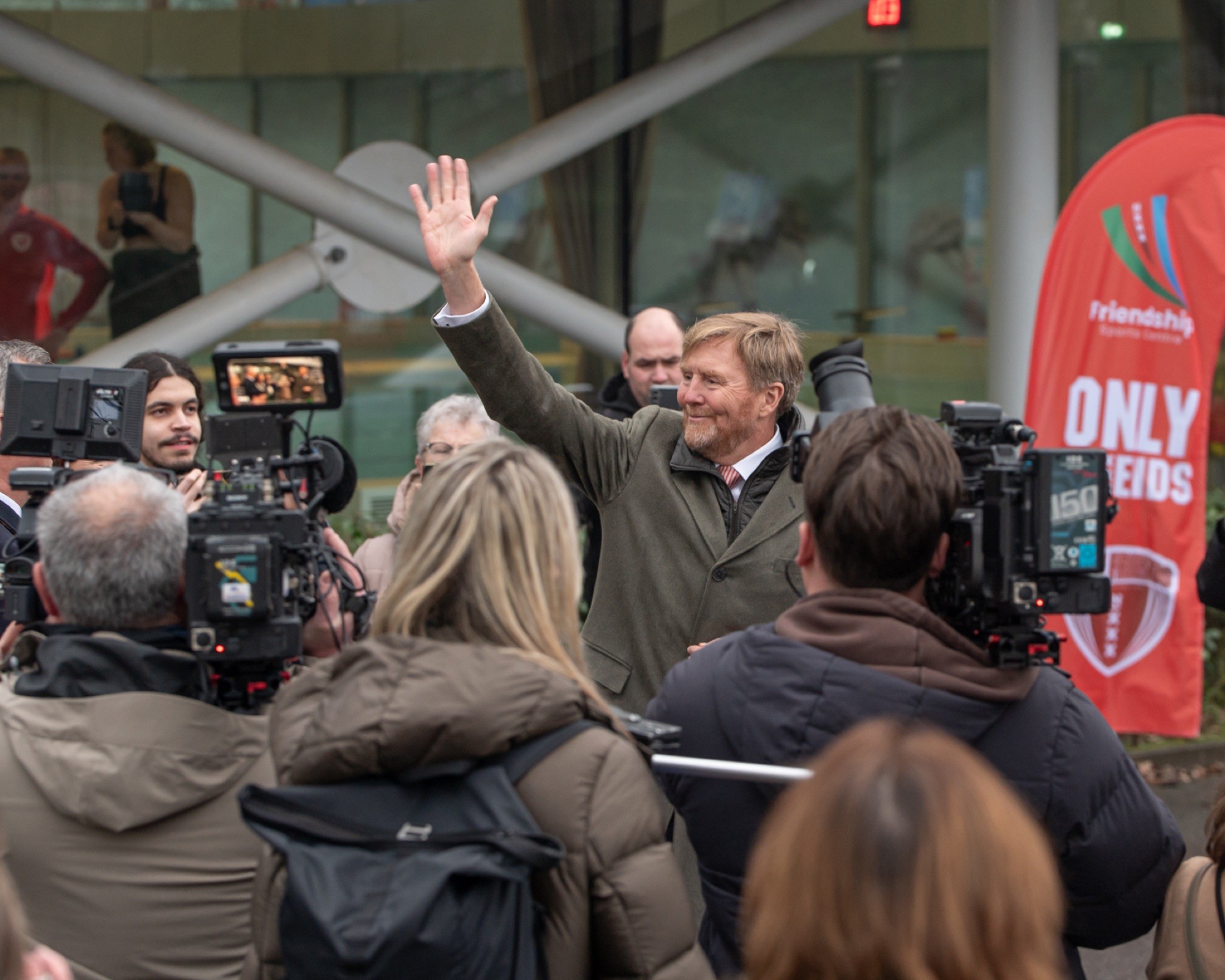 The King waves to the press outside the Friendship Sports Centre