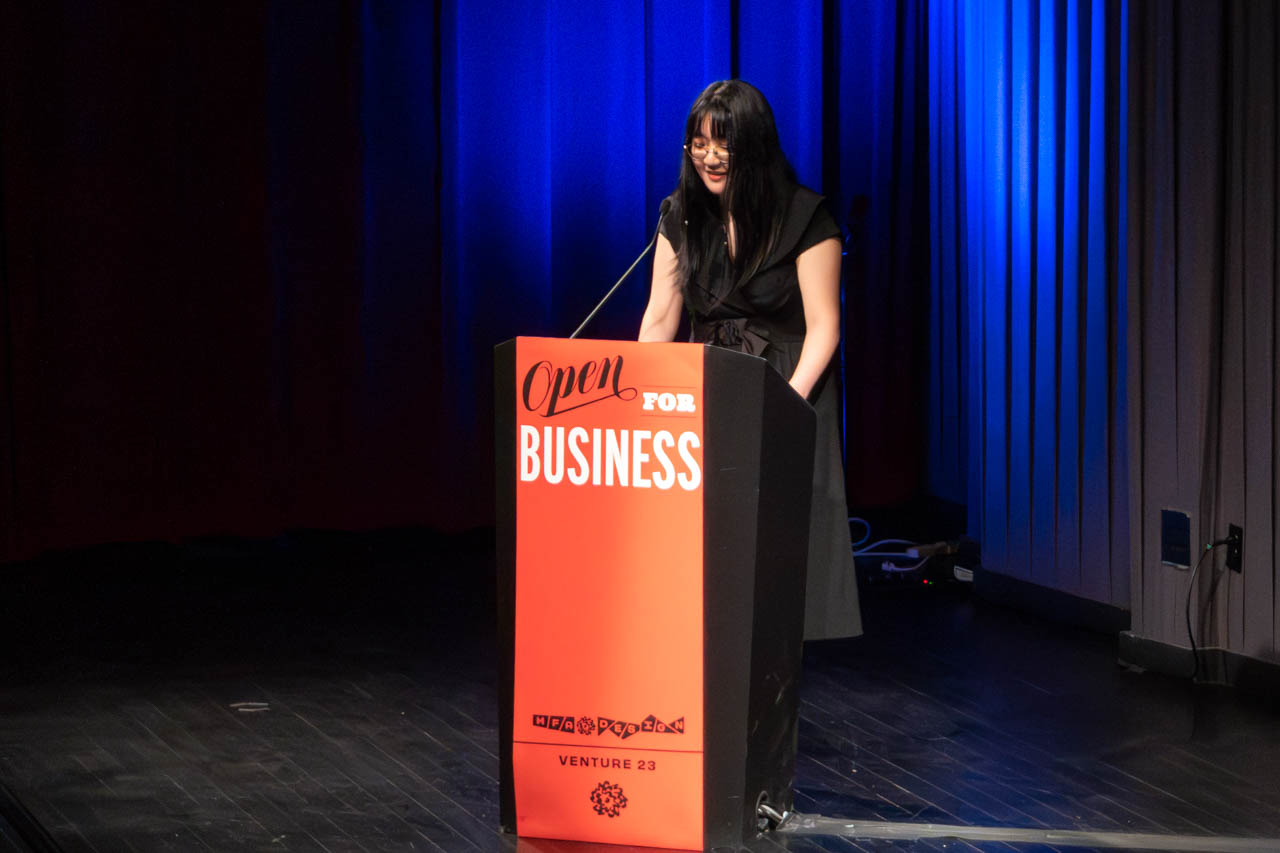 woman standing at a podium delivering a presentation