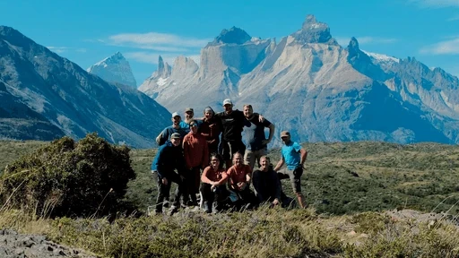 Groupe de randonneurs posant devant un massif montagneux.