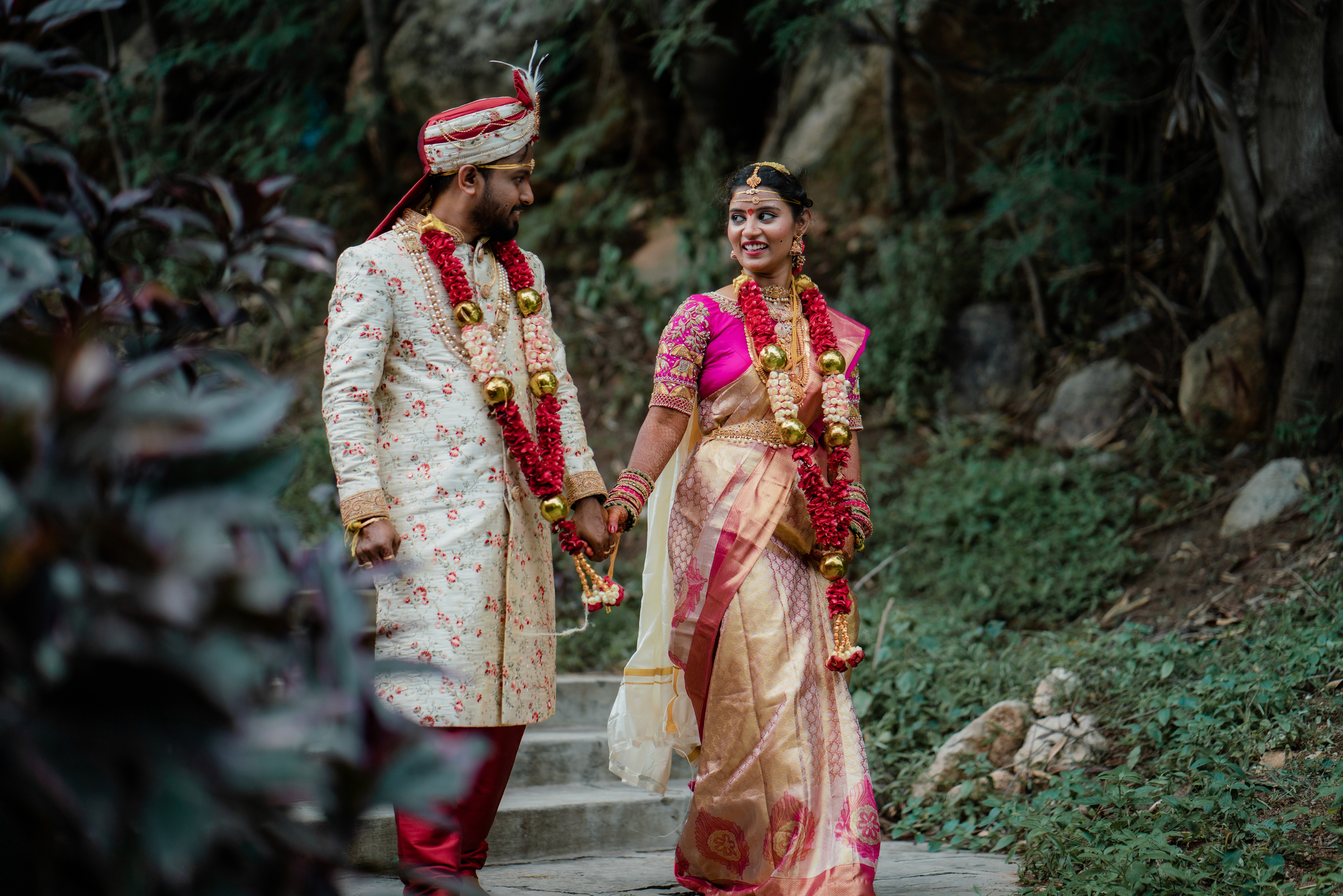a woman in a wedding dress standing in front of a flower arch