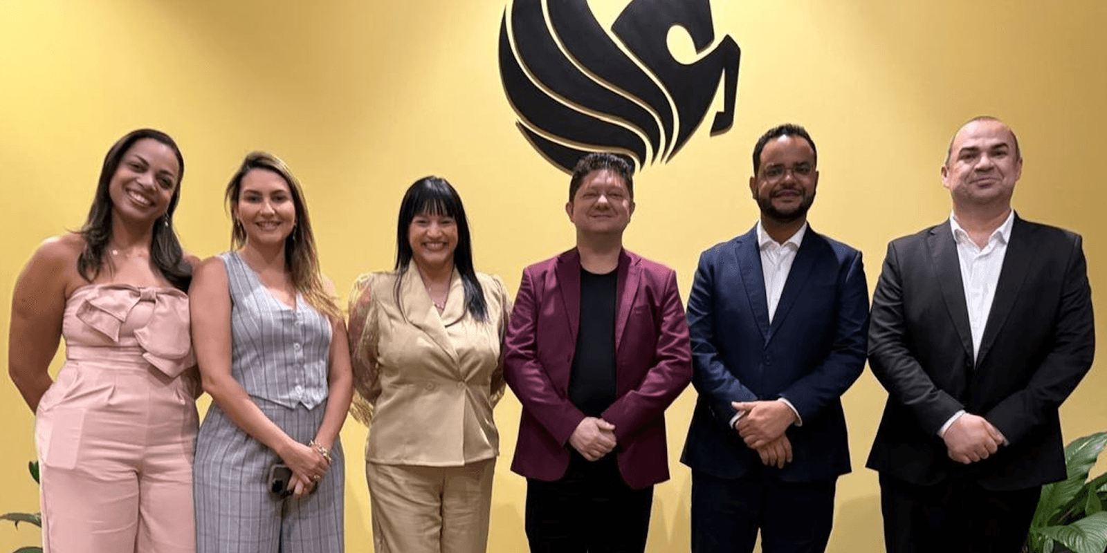 A group of individuals poses in front of the ENBER University logo, highlighting the university's focus on mentorship and scientific research.
