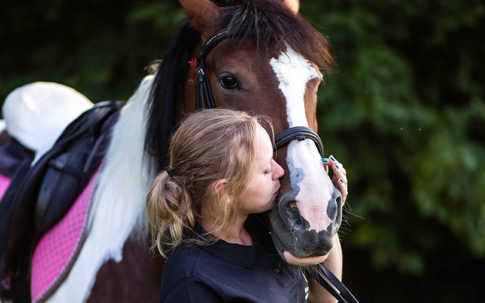 Persona besando a un caballo durante una excursión de medio día a caballo cerca de un lago en Cracovia.