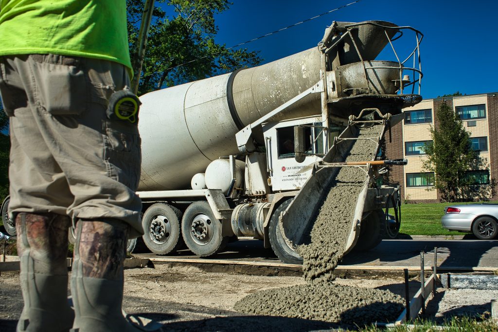 Excavator working beside large underground utility pipes
