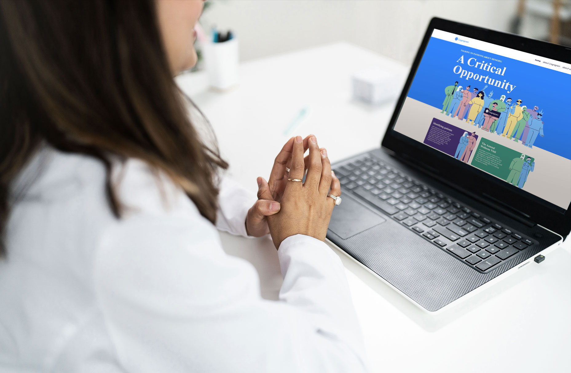 Physician sitting in front of laptop. The website that introduces a digital cognitive assessment as a critical opportunity for talking about memory.