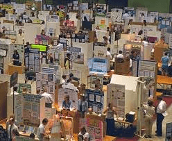 High school student presenting original research at a university conference, representing science fair alternatives for college applications