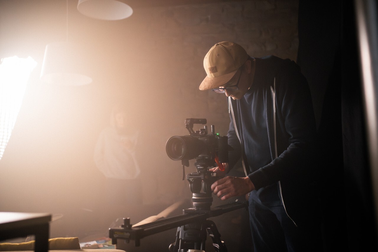 A video producer adjusting a camera setup during a studio shoot