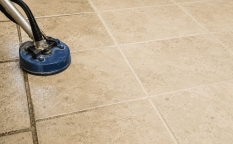 Technician applying penetrating grout sealer to a residential tile floor