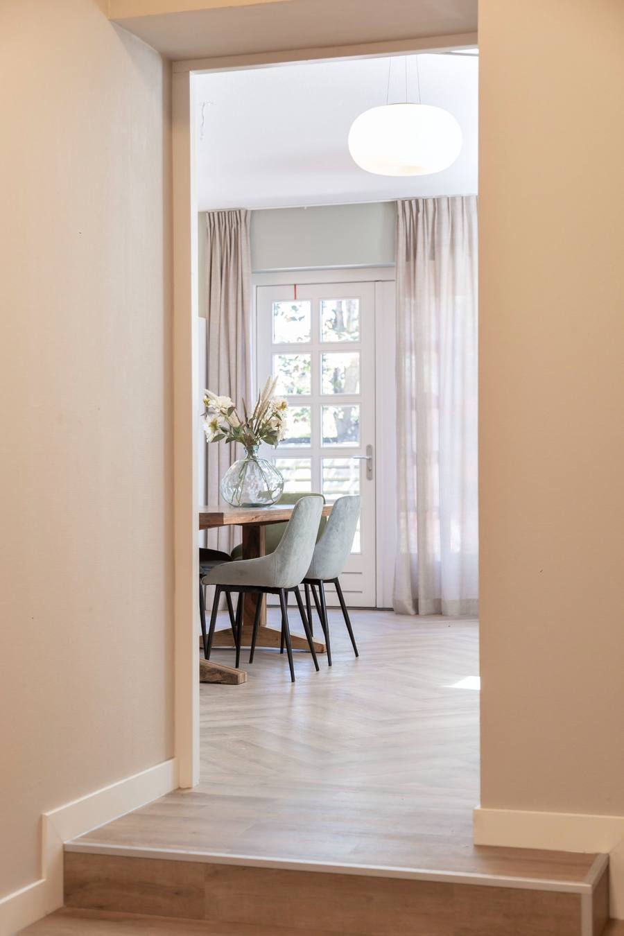 doorkijkje naar opkamer, tafel met mint groene stoelen 