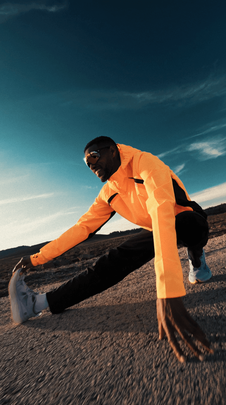 Bride sitting on ground against wall, groom standing nearby