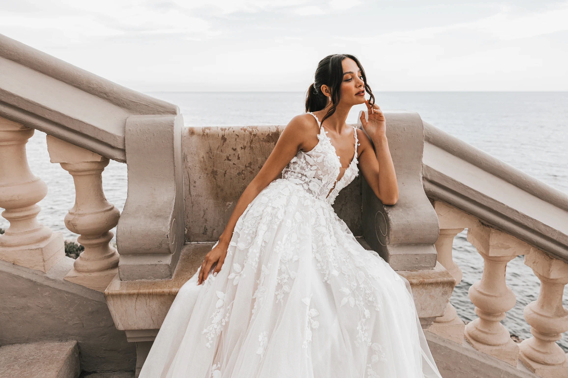 Verspieltes Brautkleid mit üppigen 3D-Blumenranken, die sich vom Dekolleté bis zur Schleppe ziehen – ein wahrer Show-Stopper.